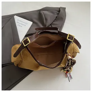 Détail du grand sac cabas en daim marron avec intérieur spacieux et détails dorés