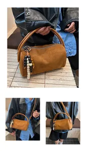 Detail of vintage brown suede cylinder bag featuring decorative beads and shoulder strap