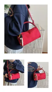 Detail view of red suede pillow bag showing shoulder, crossbody, and hand-carry styles