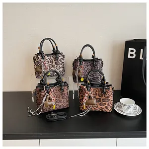 Detail view of stylish leopard print mini bags with knot handles and adjustable straps