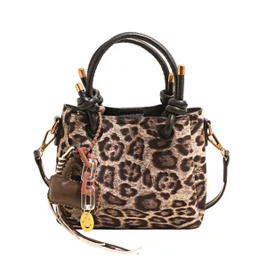Detailed view of leopard print crossbody bag with knotted handle and heart charm