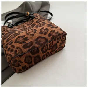 Detail of leopard print suede texture with black leather piping and gold hardware buckle