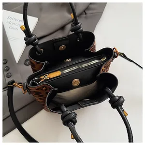 Macro shot of leopard print bucket bag interior with zipper compartment and magnetic closure
