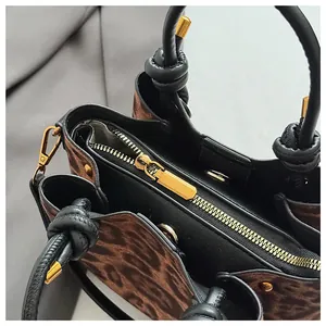 Detailed top view showing internal zipped compartments and leopard print of the bag