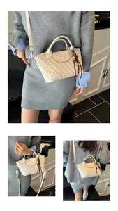 Detail der cremefarbenen Tasche aus Faltenleder mit Holzperlenquaste und Flechtstruktur