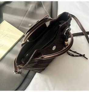 Detail der dunkelbraunen Handtasche mit Webstruktur und abnehmbarem Schultergurt