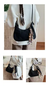 Détail du sac hobo en daim noir avec perles colorées et longs pendentifs à franges