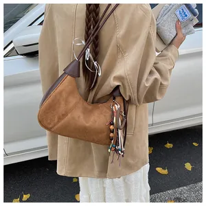 Détail du sac hobo rétro en daim marron avec pendentif à franges de style ethnique