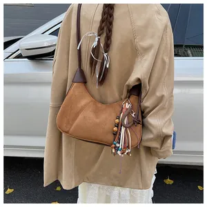 Sac bandoulière en daim marron avec pompons perlés colorés et fine bandoulière réglable