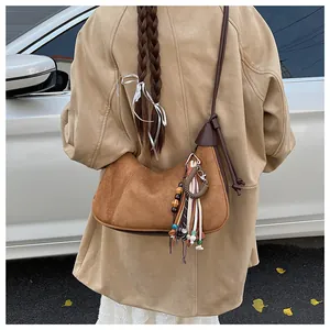 Sac hobo en daim caramel avec pompons colorés et perles en bois en vue extérieure