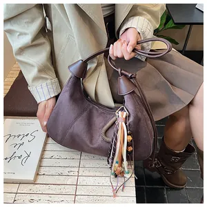 Détail du sac hobo avec franges ethniques colorées et texture en daim lisse