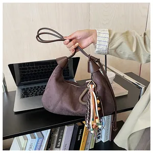 Détails du sac croissant en daim marron foncé avec glands en perles colorées et zip métal