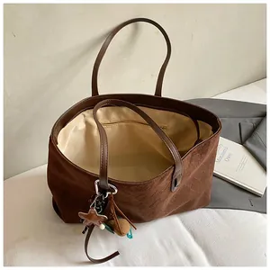 Macro shot of large brown suede tote bag interior with beige lining and zip pocket