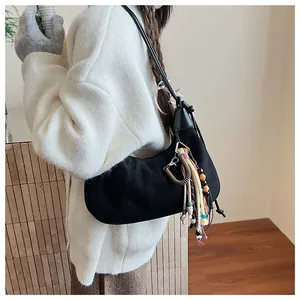 Détail du sac demi-lune en daim noir avec pampilles de perles bohèmes et breloques