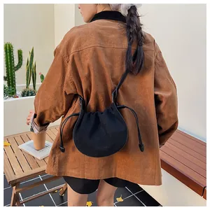 Détail d'un sac nuage plissé noir avec cordon de serrage sur une veste en velours rétro
