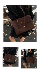 Detail of dark brown suede tote bag featuring elegant golden double twist lock closure