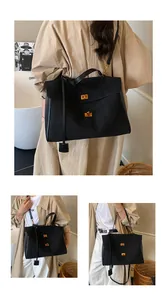 Detail of black tote bag with gold twist lock and smooth matte leather texture