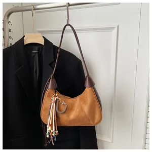 Détail du sac vintage en daim avec garniture en cuir et breloques de perles colorées