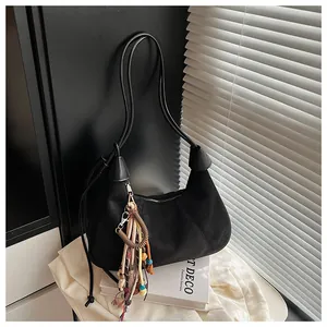 Détail du sac hobo en daim noir avec pendentif ethnique à franges et bordure en cuir