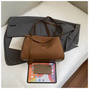 Close-up of caramel leather tote bag with gold twist lock and interior storage space