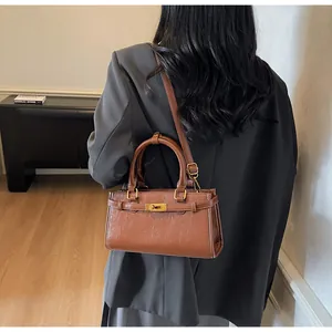 Gros plan sur un sac à main rétro marron avec texture plissée et boucle en métal doré