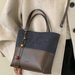 Vintage-style two-tone bucket bag with suede finish and No Filter debossed text