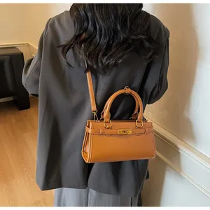 Détail de la texture en cuir marron et du fermoir doré sur un sac à main rétro élégant