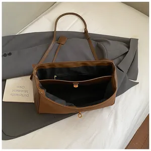 Detail view of the brown leather bag interior with multiple compartments and gold twist lock