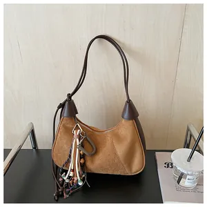 Détails du sac hobo vintage en daim avec pompons ethniques et patchwork de cuir