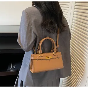 Détail d'un sac à main en cuir marron clair avec boucle en métal doré et bandoulière