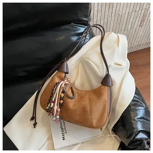Vue détaillée du sac croissant en daim marron avec pampilles colorées et bandoulière