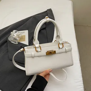 Détail du sac à main blanc rectangulaire avec fermoir doré et texture cuir délicate