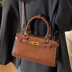 Sac à main rectangulaire en cuir verni marron avec fermoir doré et bandoulière