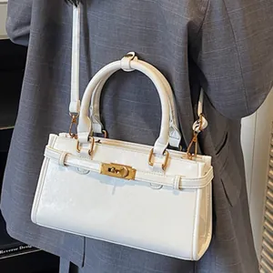Sac à main minimaliste en cuir blanc avec fermoir doré et bandoulière élégante