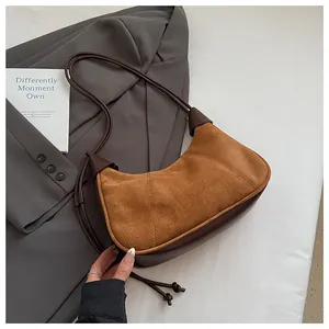 Détail du sac hobo en daim vintage avec base en similicuir contrasté et fines lanières