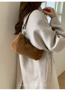 Dettaglio borsa hobo in camoscio marrone con tracolla sottile e chiusura a zip liscia