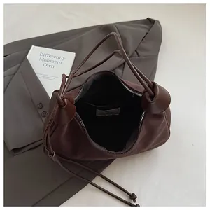 Détail de l'intérieur du sac bandoulière en daim marron foncé avec poche zippée