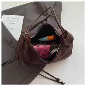 Détail de l'intérieur du sac dumpling en daim marron avec une poche zippée pratique