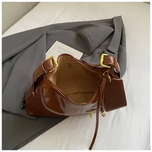 Vintage brown glossy tote bag with gold hardware and card holder on grey blazer