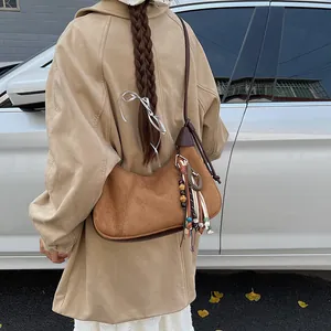 Sac demi-lune en daim marron vintage avec pampilles bohèmes et détails de perles