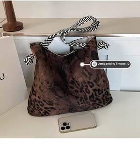Detail view of large leopard print tote bag size compared with an iPhone 12