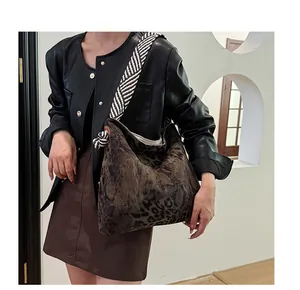 Detail view of large leopard print hobo bag with striped woven strap and knot accents