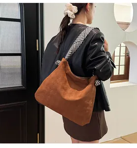 Detail of brown tote bag with checkered texture and black white striped strap