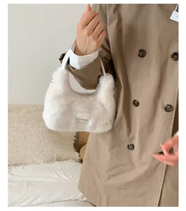 Detail der weißen Faux-Fur-Hobo-Tasche mit Leder-Logo-Patch und Tragegriff