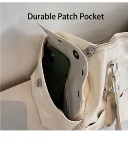 Detail view of durable side pocket on cream travel tote bag showing smartphone storage capacity