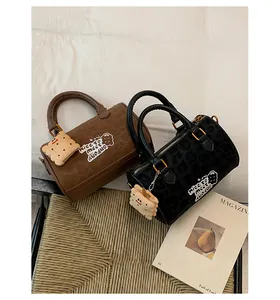 Detail of leopard print boston bags with cute plush charms and embroidery in warm setting