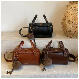 Trois sacs cylindriques en cuir rétro noir et marron avec des breloques en peluche