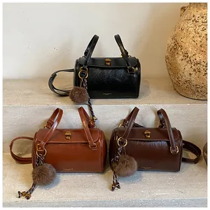 Gros plan de sacs polochons minimalistes en noir et marron avec pendentifs en peluche