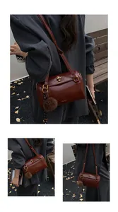 Vue street style d'un sac cylindre en cuir marron vintage avec garniture dorée élégante