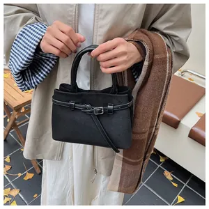 Detail der minimalistischen schwarzen Wildleder-Eimertasche mit Zierschnalle auf der Straße